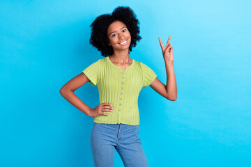 Photo of optimistic nice positive girl with perming coiffure green t-shirt showing v-sign hand on...