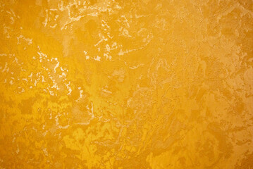 Decorative golden plaster texture on the wall - background