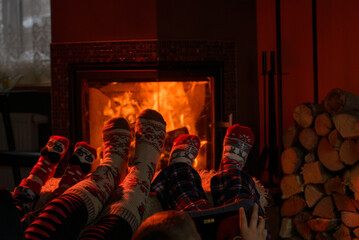 Naklejka premium Family of Feet warming at a fireplace