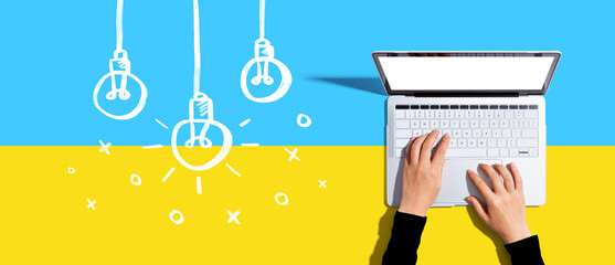 Hanging idea light bulbs with a laptop computer