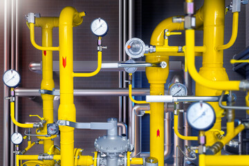 Gas control equipment. Yellow pipeline in basement. Natural gas supplies. Regulators and pressure reducers on gas pipelines. Industrial equipment near brick wall. Fuel, propane, methane. 3d image. - obrazy, fototapety, plakaty