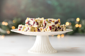 A pedestal stand topped with cranberry and pistachio white chocolate fudge.