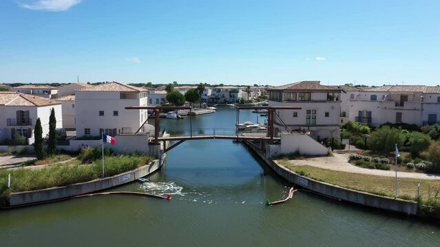 entering Marina du Port du Roy aerial shot Aigues-Mortes with french flag