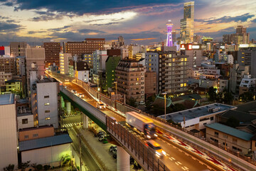 Fototapeta na wymiar Evening Japan. Panorama of Osaka. Car overpass in Japanese city. Japanese architecture. Evening cityscape of Osaka. Sunset over city of Japan. Asian architecture. Osaka view from quadcopter