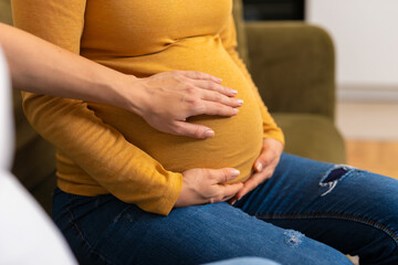 Pregnant woman talking in the room.Women holding hand on the belly