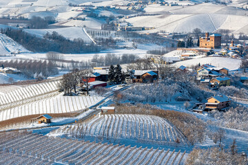 View from above of the hills and vineyards covered with white snow in Piedmont, Italy.