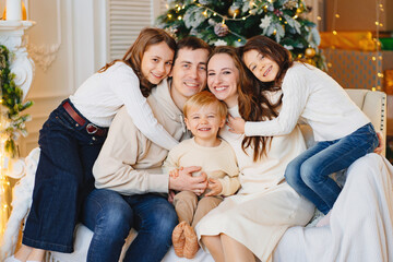 Beautiful happy large family on the couch by the Christmas tree.