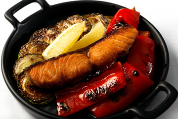 salmon steak with grilled vegetables on a white background