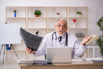 Old male doctor radiologist working in the clinic