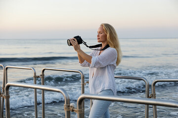 Photographer, woman and camera at beach for travel vacation or holiday in summer sun.