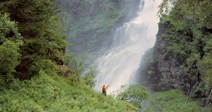 Freedom, hiker and nature with a photo being taken by person with adventure by a Norwegian waterfall. Jungle, forest and mobile picture of a traveler on tourism trip in Norway environment