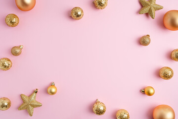 Christmas ornaments on light pink background. Various decorations, baubles and stars. Festive frame. Minimal composition. New year sale template. Flat lay, top view, copy space.
