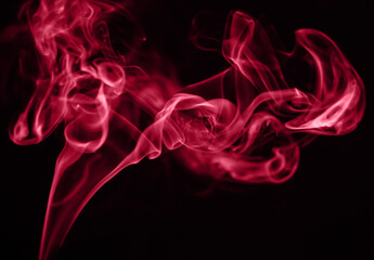 Beautiful red smoke on a black background. Color of the year 2023 - Viva Magenta
