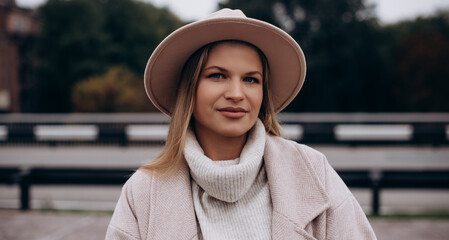 Portrait of elegant young woman in a woolen sweater and a white felt hat