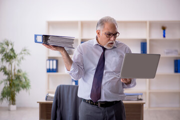 Old male employee doing sport exercises during break