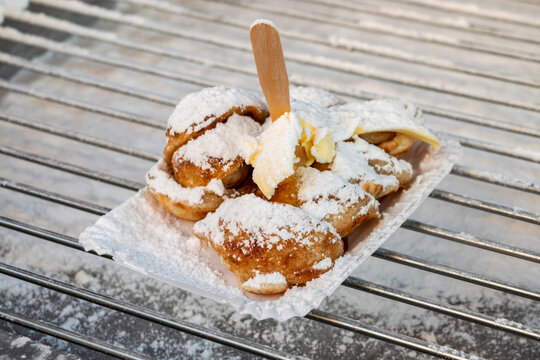 Dutch poffertjes with powdered sugar close-up. Cooking Dutch traditional street food small pancakes poffertjes at the winter and autumn market in the Netherlands. 