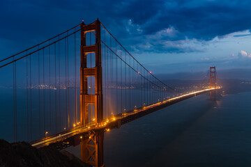 Fototapeta na wymiar Golden Gate Bridge at Night with dark stormy clouds
