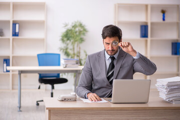 Young male employee and too much work in the office