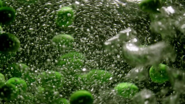 Slow motion close-up video of green peas being cooked in water. Beautiful background video of cooking healthy food in the kitchen. High quality 4k footage