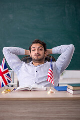 Obraz premium Young male English language teacher sitting in the classroom