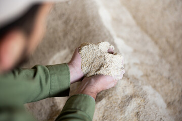 Close up view of male farmer holding bunch of corn flour.