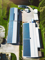 Vertical photo top down aerial view solar panels on the roof of two warehouses in the countryside © VisualProduction