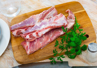 Raw fesh spare ribs and parsley on wooden cutting board