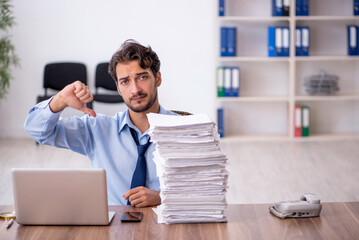 Young male employee and too much work in the office