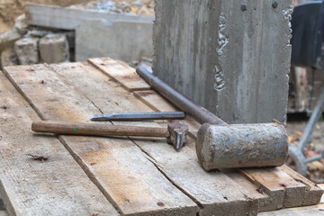 A chisel and two hammers on the work table in the construction site - Construction concept