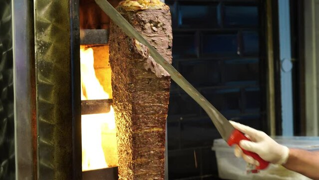 Meat doner cut close-up videos, cutting hanging doner. Turkish kebab iskender. Shawarma meat being cut before making