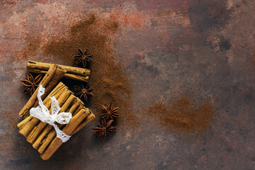 Cinnamon sticks and anise stars on dark background. Copy space for your text. Christmas spices.