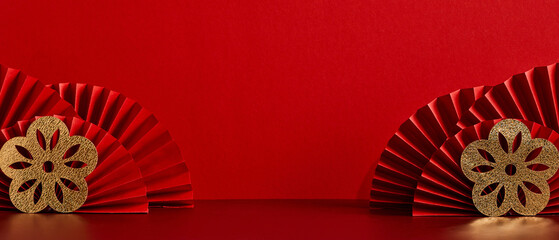 Happy Chinese New Year 2023 year of the rabbit concept. Red paper fans decorated gold flowers on red table.