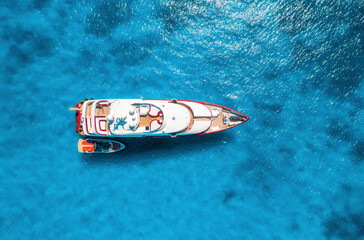 Aerial view of beautiful luxury yacht and boat in blue sea at sunset in summer. Sardinia island,...
