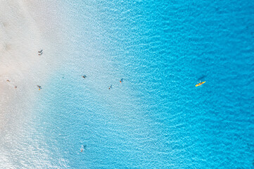 Luchtfoto van de verbazingwekkende zeekust. Bovenaanzicht van gedreun van strand met wit zand, zwemmende mensen in blauw transparant water op zonnige dag. Zomer op het strand van La Pelosa, Sardinië, Italië. Tropisch landschap