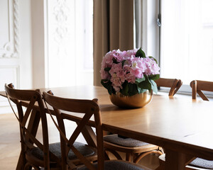 Wooden table with chairs in the living room. Stylish modern interior in Scandinavian style.