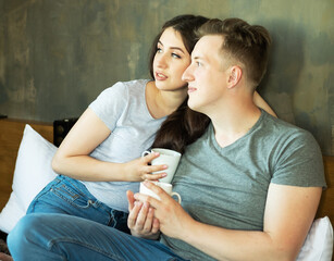 young beautiful couple drinking coffee in bed at morning, lifestyle concept