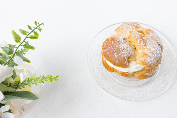 Choux Bun dessert on plate. French pastry, white background copy space
