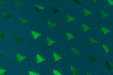 Christmas tree confetti pattern on green. Abstract background