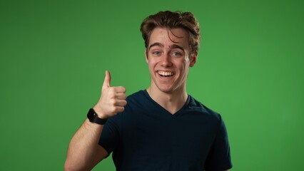 Waving and smiling, confused young man 20s posing isolated on green screen background in studio. People lifestyle concept.