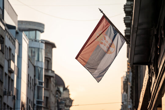 Photo Of The Official Flag Of The Republic Of Serbia, With A Backround Of The Streetof Kneza Mihailova In Belgradeduring Sunny Sunset Sky.Serbia Is A Nation Of Balkans, In Europe....