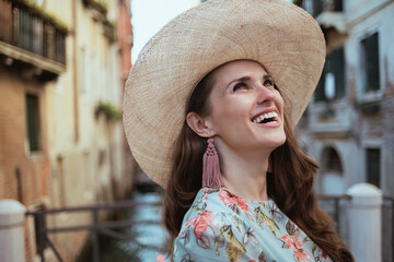 smiling stylish woman in floral dress enjoying promenade