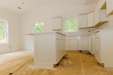 Installation of white kitchen cabinets in a newly constructed house