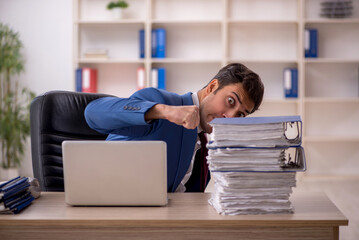 Young male employee and too much work in the office