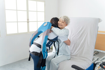 パワーアシストスーツを着けて高齢者を介助する介護士