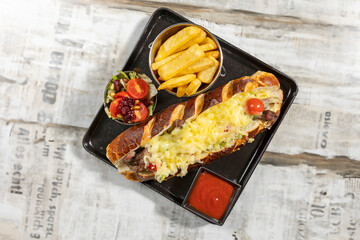 Cheese beef sandwich served with french potatoes