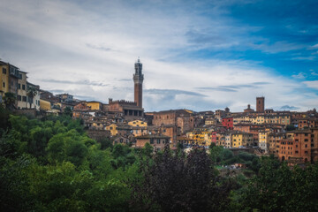 Fototapeta na wymiar Beautiful panoramic view of the historic city of Siena at daytime with an amazing cloudscape on an idyllic autumn evening, Tuscany, Italy. Long exposure picture. October 2022