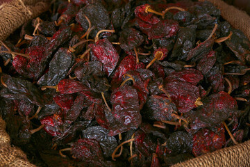 Heap of Ancho chile peppers in sack, closeup