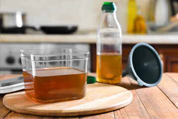 Used cooking oil on wooden table in kitchen, space for text