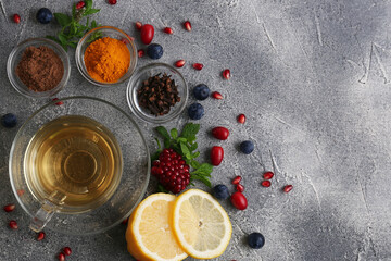 Cup with delicious immunity boosting tea and ingredients on grey table, flat lay. Space for text