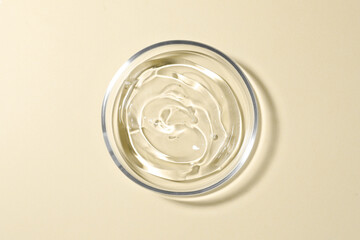 Petri dish with liquid on beige background, top view